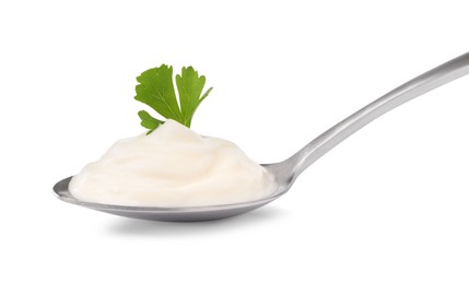Delicious sour cream with parsley in spoon on white background