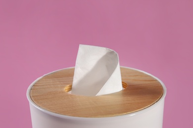 Holder with paper tissues on pink background, closeup
