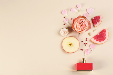 Flat lay composition with bottle of perfume on beige background, space for text