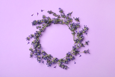 Frame made with lavender flowers on violet background, flat lay. Space for text
