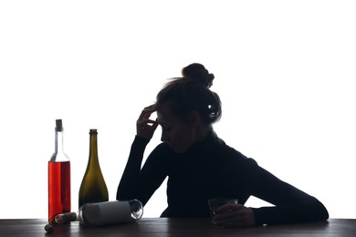 Alcohol addiction. Woman with glass and bottles on white background