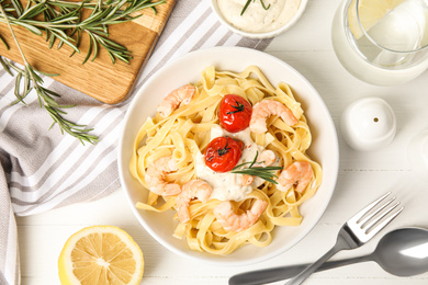 Delicious pasta with shrimps served on white wooden table, flat lay