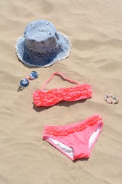 Jeans hat, sunglasses and bikini on sand. Beach accessories