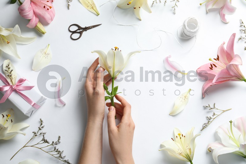 Woman with beautiful lily flower on white background, top view