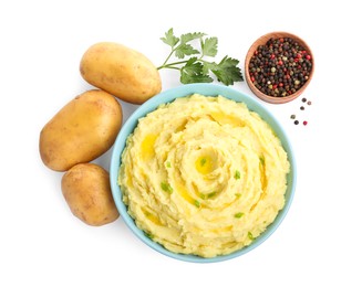Bowl of tasty mashed potatoes with ingredients on white background, top view