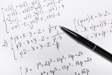 Sheet of paper with mathematical formulas and pen, top view