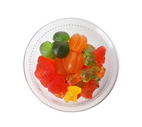 Different delicious gummy candies in glass bowl on white background, top view
