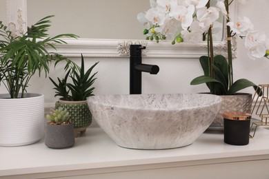 Stylish sink and beautiful houseplants in bathroom. Interior design