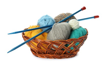 Wicker basket with different balls of woolen knitting yarns and needles on white background