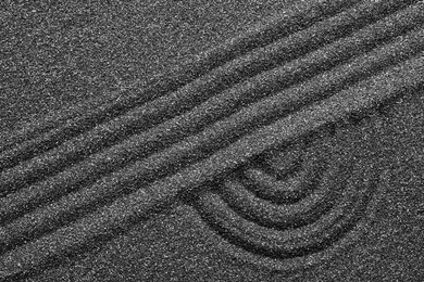 Pattern on decorative black sand, top view. Zen and harmony