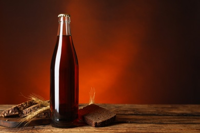 Bottle of delicious fresh kvass, spikelets and bread on wooden table. Space for text