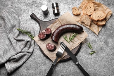 Tasty blood sausage with rosemary on grey table, flat lay