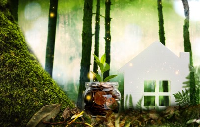 Eco friendly home. House model and jar with coins in forest