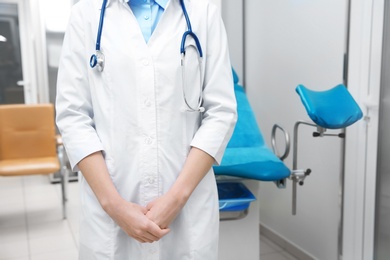 Young gynecologist in white coat at workplace, closeup