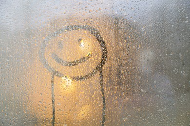 Happy face drawn on foggy window, space for text. Rainy weather