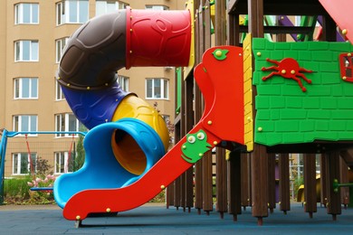 Photo of Colourful slides on outdoor playground for children in residential area