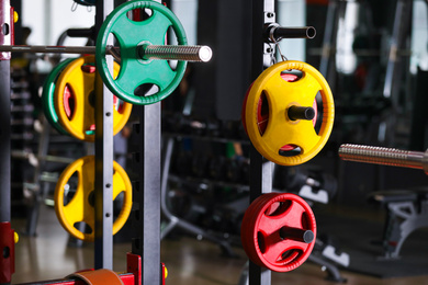 Barbell weight plates on rack in gym