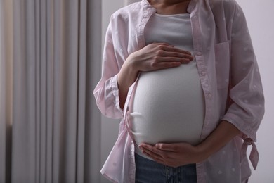 Young pregnant woman at home, closeup view. Space for text
