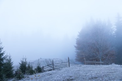 Beautiful view of countryside with hoarfrost and thick fog