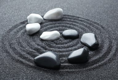 Stones on black sand with beautiful pattern. Zen and harmony