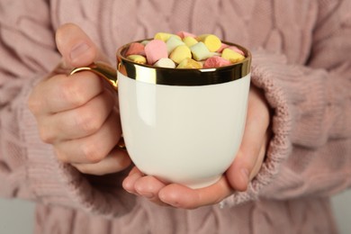 Woman holding cup of delicious hot chocolate with marshmallows, closeup