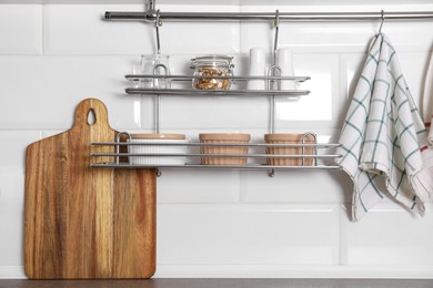 Kitchen towel hanging on hook rod and shelves with ramekins indoors