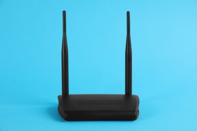 Modern Wi-Fi router on light blue background