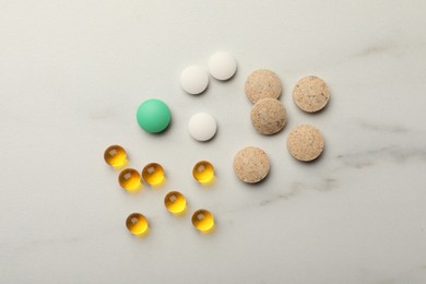Different dietary supplements on white table, flat lay