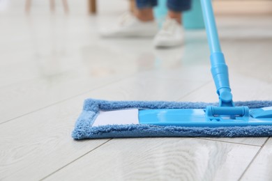 Washing of parquet floor with mop indoors, closeup
