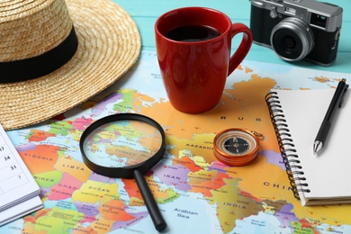 World map and different travel accessories on table. Planning summer vacation trip