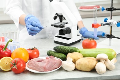 Scientist checking products at table in laboratory, closeup. Quality control
