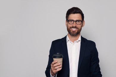 Smiling bearded man with glasses and paper cup on light grey background. Space for text