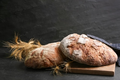Tasty freshly baked bread on black table