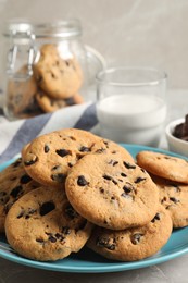 Plate with delicious chocolate chip cookies on grey marble table, closeup