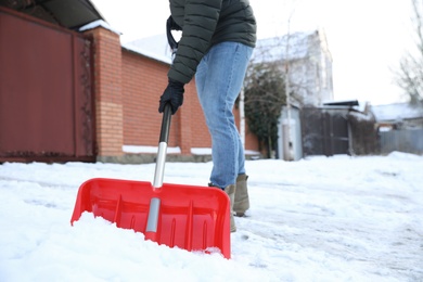 Person shoveling snow outdoors on winter day, closeup