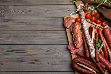Different tasty sausages on wooden table, top view. Space for text