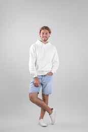 Photo of Full length portrait of man in hoodie sweater on light background. Space for design