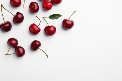 Photo of Many sweet ripe cherries on white background, flat lay. Space for text