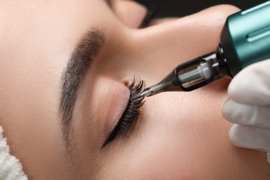 Young woman undergoing procedure of permanent eye makeup, closeup