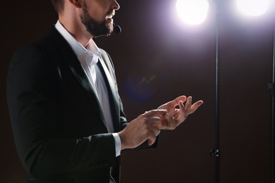 Motivational speaker with headset performing on stage, closeup