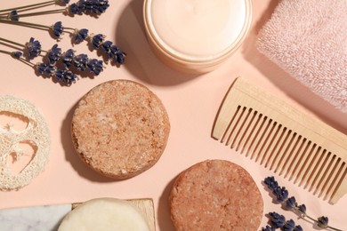 Flat lay composition of solid shampoo bars, lavender and comb on pink background. Hair care
