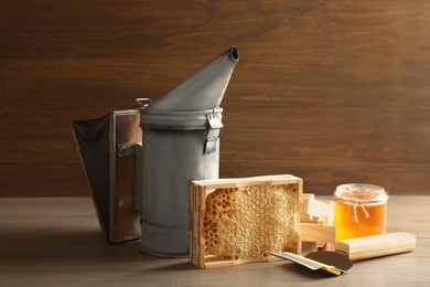 Composition with honeycomb and beekeeping tools on wooden table