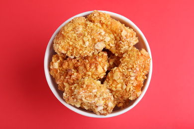 Bucket with yummy nuggets on pink background, top view