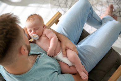 Father with his newborn son at home, above view