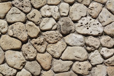 Texture of beige stone wall as background, closeup