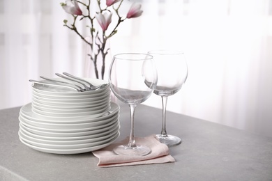 Set of clean dishes on table against blurred background