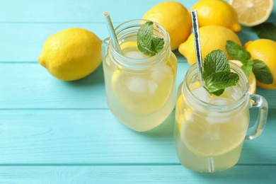 Natural lemonade with mint on light blue wooden table, closeup. Summer refreshing drink