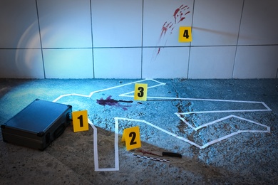 Photo of Crime scene with evidences and chalk outline on floor. Detective investigation