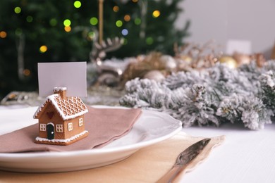 Photo of Beautiful festive place setting with blank card and decor for Christmas dinner on table, closeup. Space for text