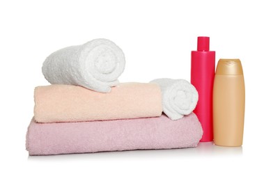 Soft terry towels and cosmetic products on white background